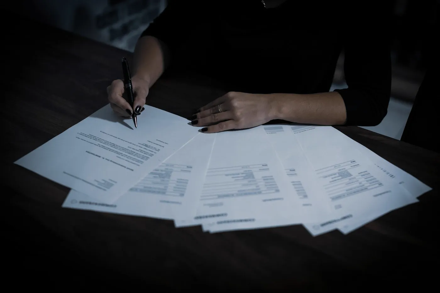 Duas pessoas analisando documentos sobre a mesa